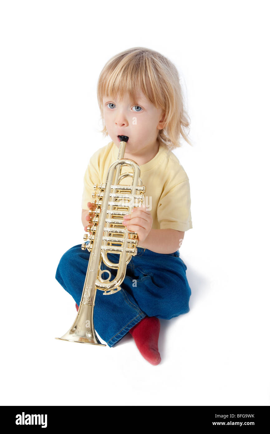 Junge mit langen blonden Haaren mit Spielzeug Trompete spielen Stockfoto