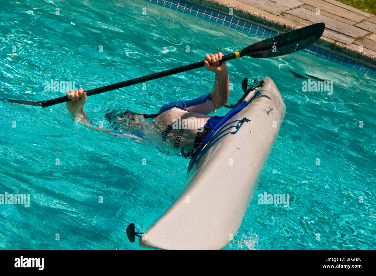 BRIARCLIFF MANOR, New York, USA - Mann übt Eskimo Rolle im Kajak, im Schwimmbad. Stockfoto