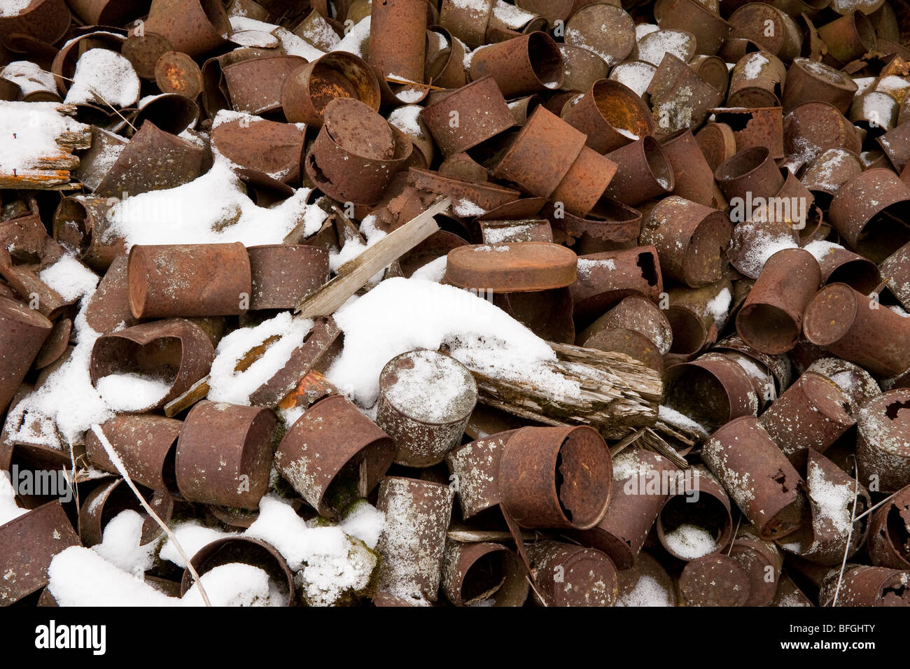 Haufen Rost aus alten Blechdosen und Neuschnee Stockfoto