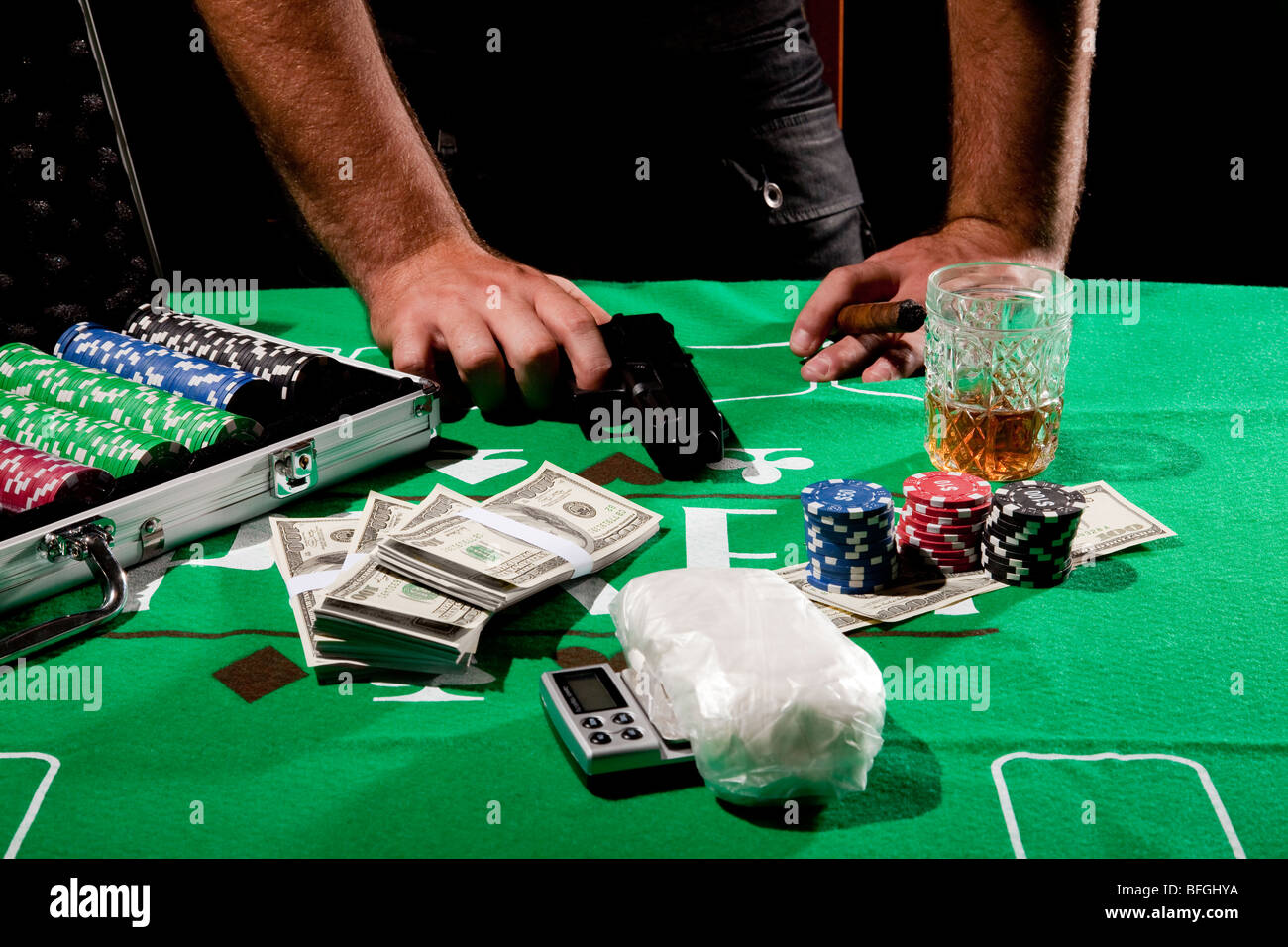 Eine junge männliche Spieler am Spieltisch greift nach seiner Hand Pistole Model-Release verfügbar Stockfoto