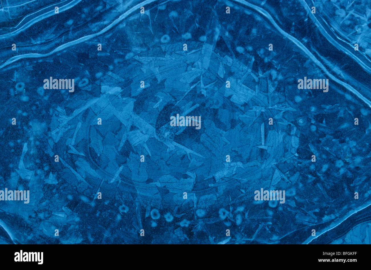 Abstrakte Muster auf dem blauen Eis eines gefrorenen Pfütze. Stockfoto