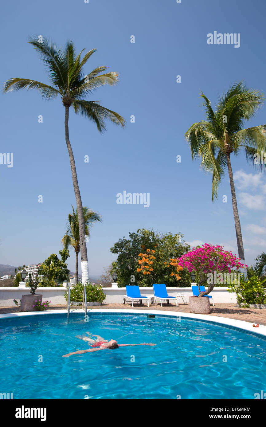 Frau, Schwimmen im Pool mit Palmen, Manzanillo, Jalisco, Mexiko Stockfoto