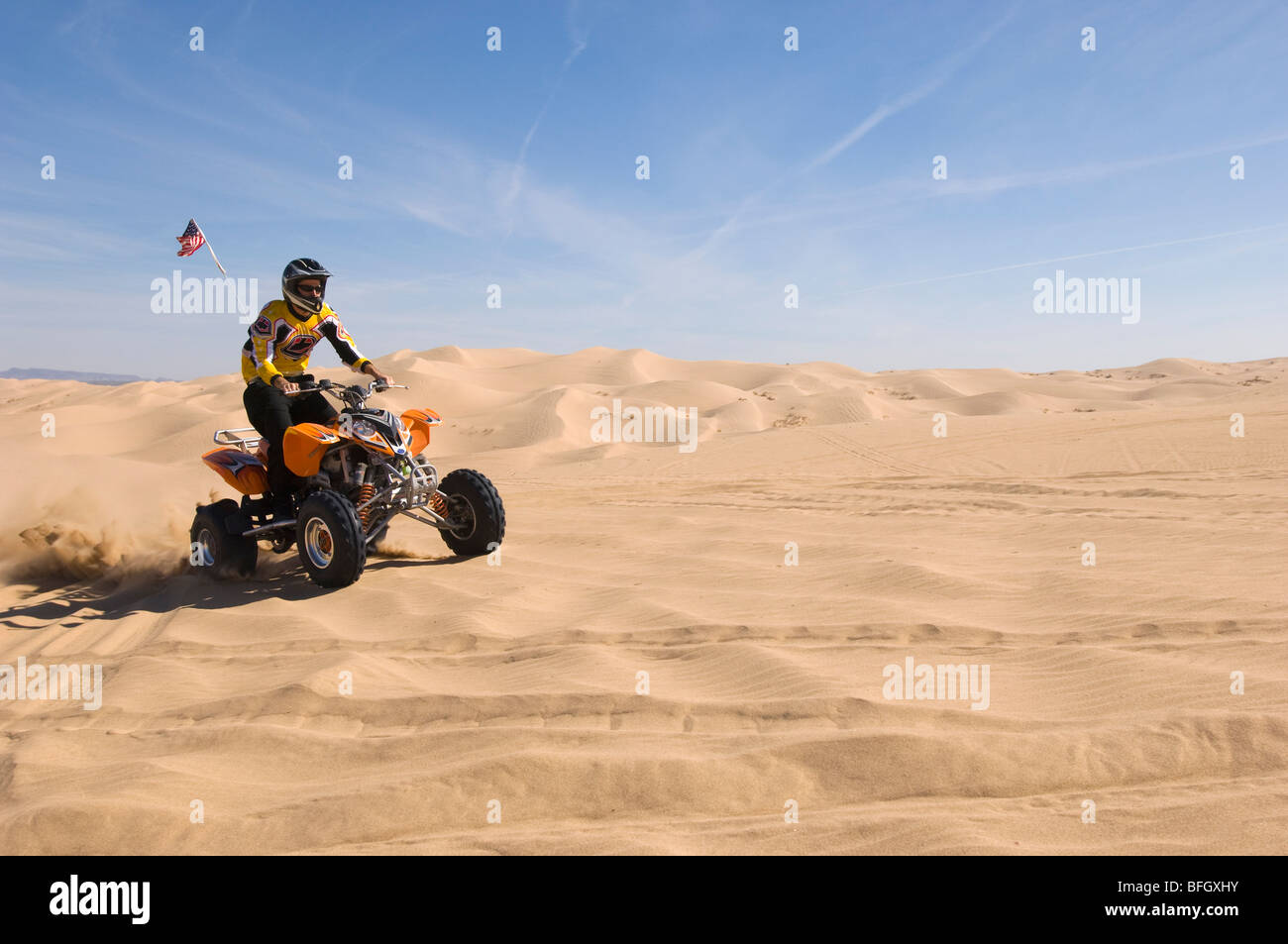 Junger Mann Reiten ATV über Sanddüne Stockfoto