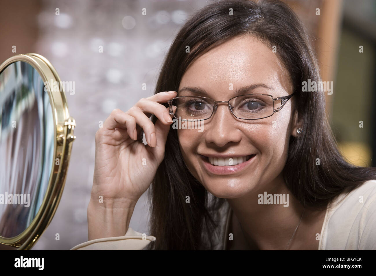 Frau versucht auf Brillen im Shop Stockfoto