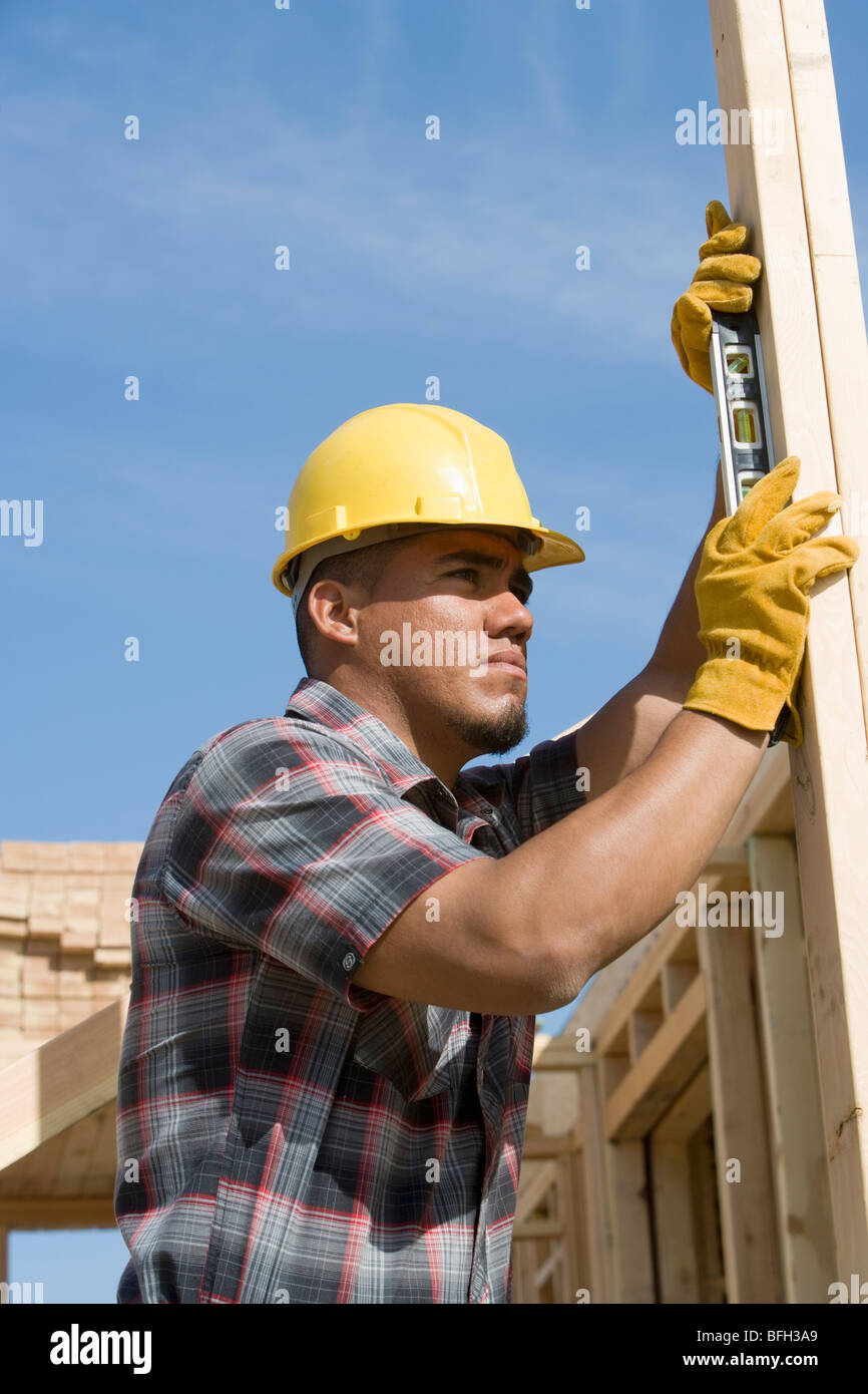 Bauarbeiter mit Wasserwaage auf Gebäude Stockfoto