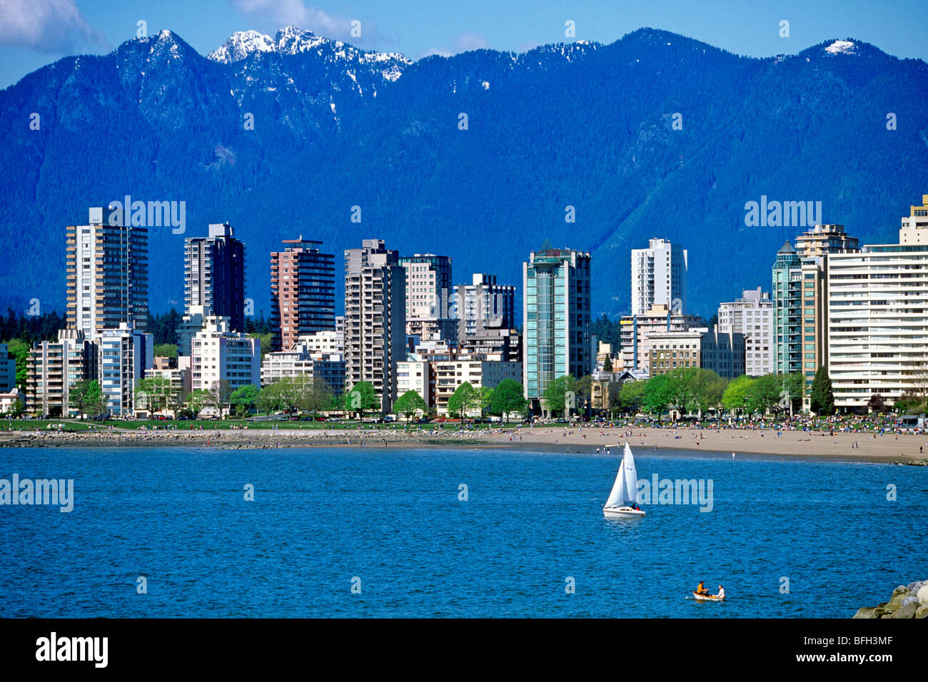 Segelboot in English Bay mit Eigentumswohnungen und Bergen im Hintergrund, Vancouver, Britisch-Kolumbien, Kanada Stockfoto