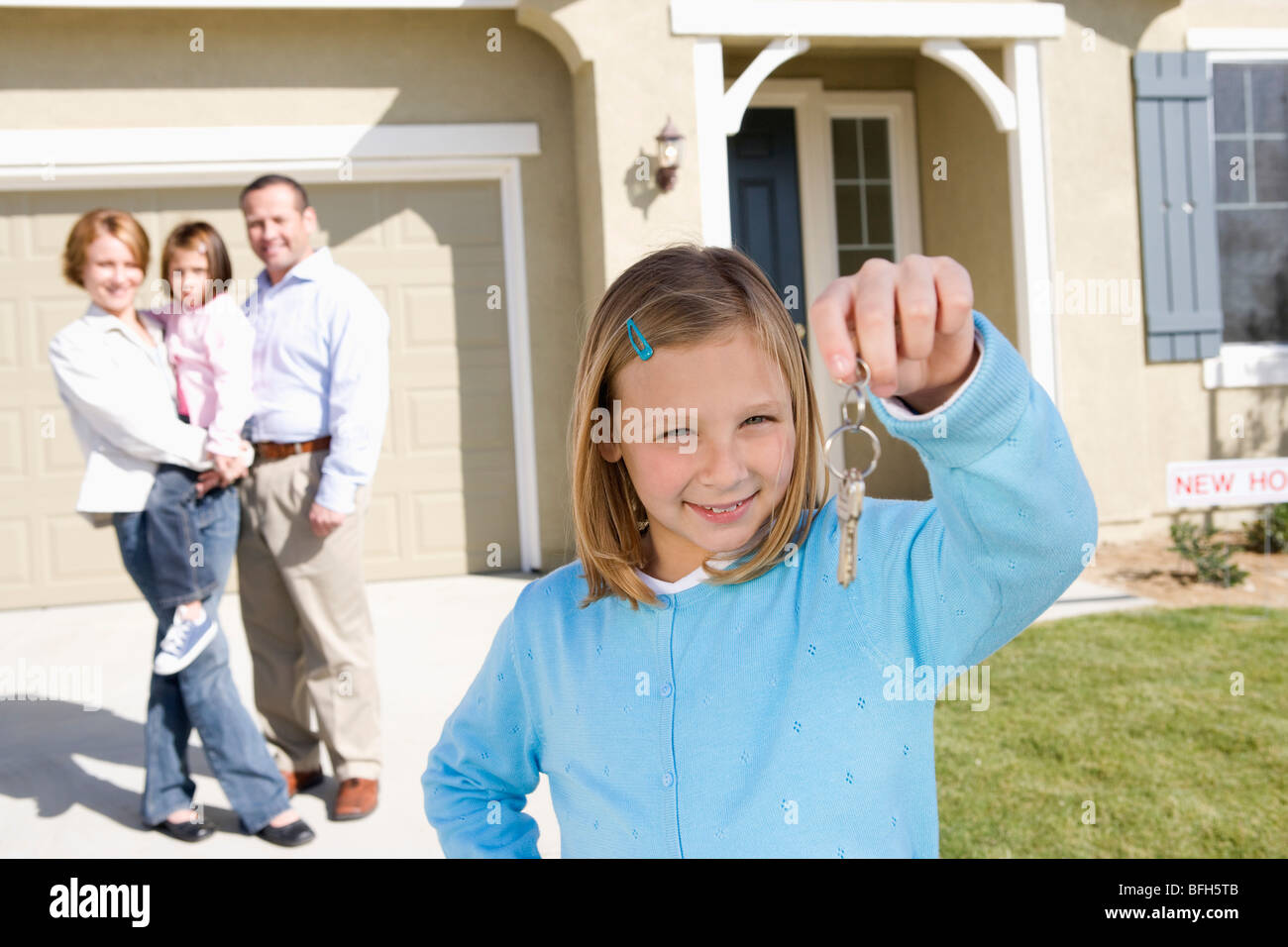 Mädchen (7-9) Betrieb Schlüssel, rest der Familie im Hintergrund Stockfoto