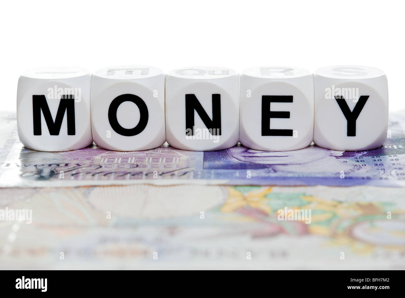 Geld buchstabiert im Brief Würfel auf einem zwanzig und zehn-Pfund-Note. Stockfoto