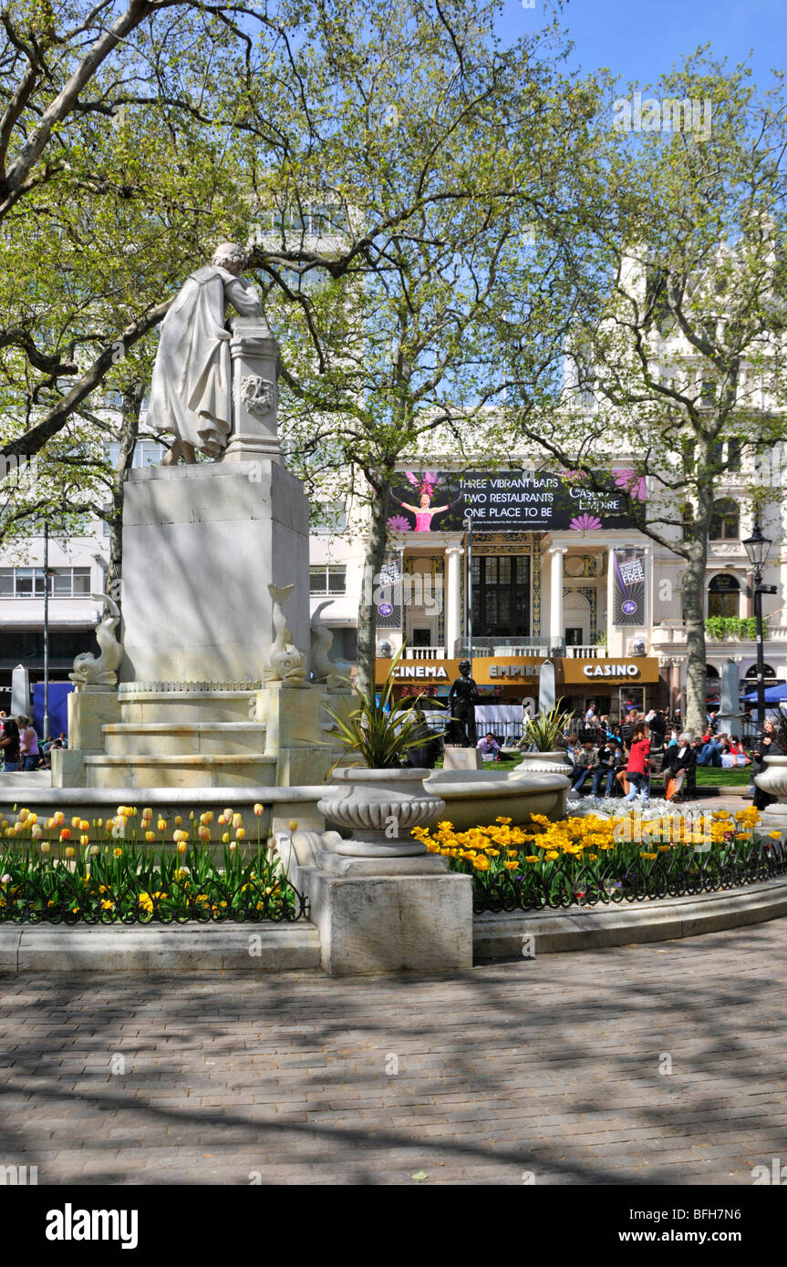Blue Sky Day am Leicester Square Frühlingszwiebeln in Blumengärten mit William Shakespeare-Statue und Casino im Empire-Kino London England Stockfoto