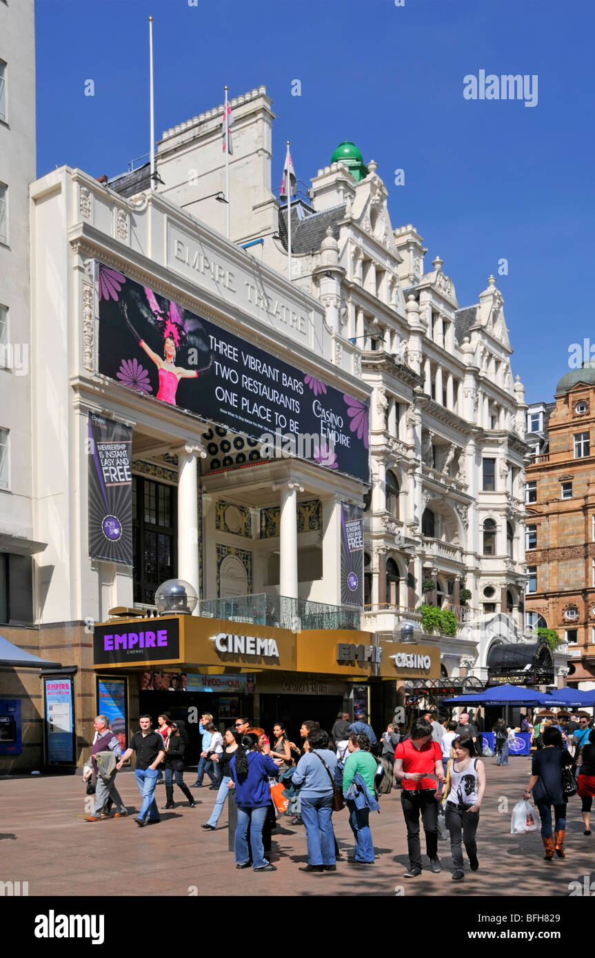 Geschäftiger Bürgersteig mit Leuten vor dem Empire Cinema und Casino Gebäude am blauen Himmel sonniger Frühlingstag in Leicester Square West End London England Großbritannien Stockfoto