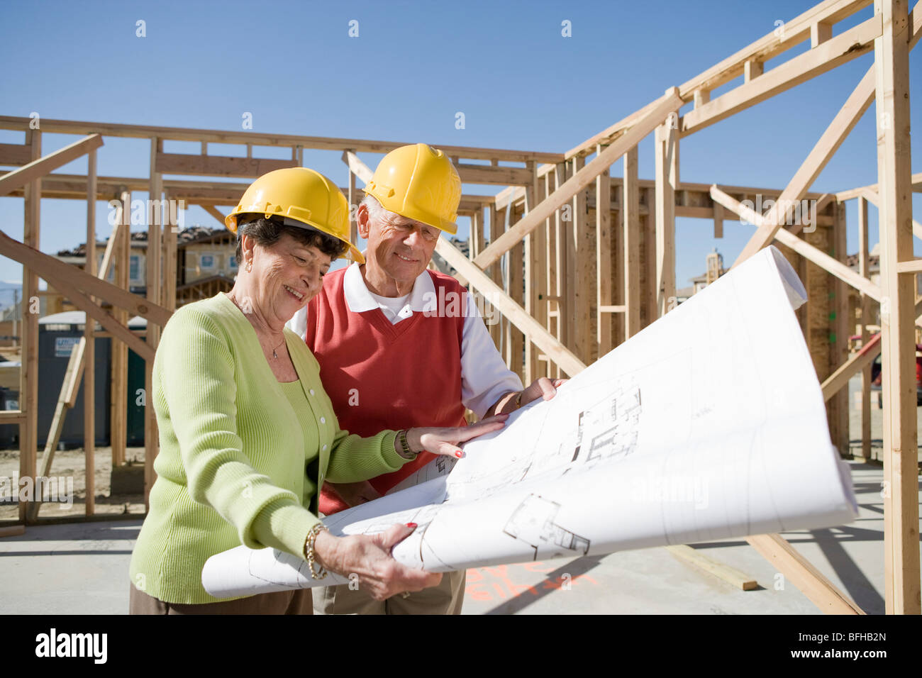 Ältere Mann und Frau Prüfung Blaupause in Baustelle Stockfoto