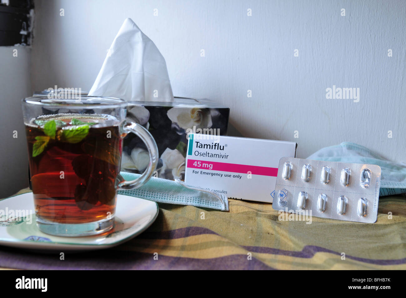 Eine medizinische Gesichtsmaske, eine Packung Tamiflu Tabletten, Gewebe und eine Tasse heiße Minze Tee gegen Schweinegrippe, 30. Oktober 2009. Stockfoto