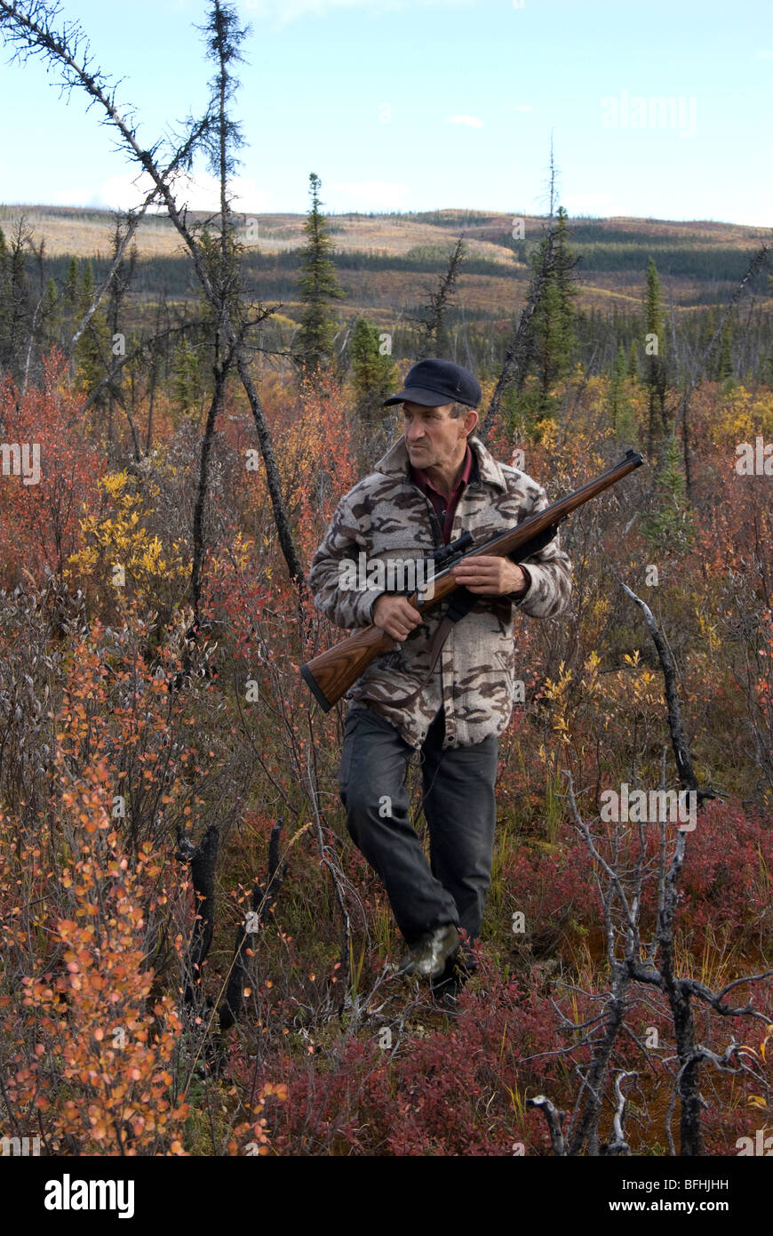 Jäger mit Gewehr zu Fuß durch Herbst Low-Land-Bürste auf der Suche nach Spiel. Stockfoto
