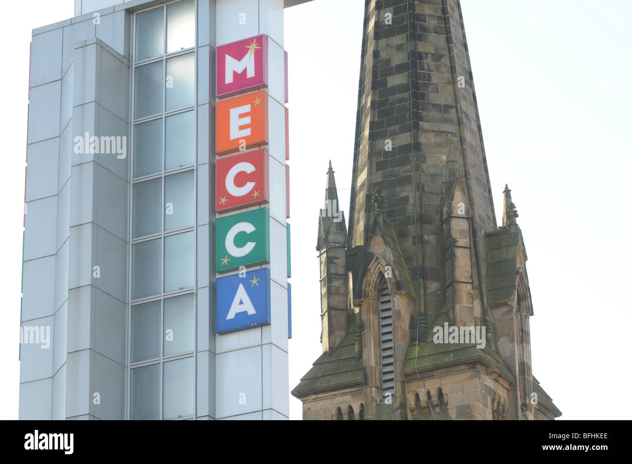 Das Wort Mekka auf einem Glasturm neben einem Kirchturm. Stockfoto