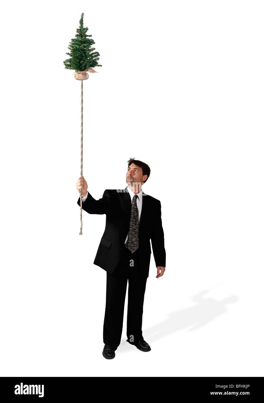 Geschäftsmann hält einen schwimmende Bäumchen Baum an einem Seil befestigt. Stockfoto