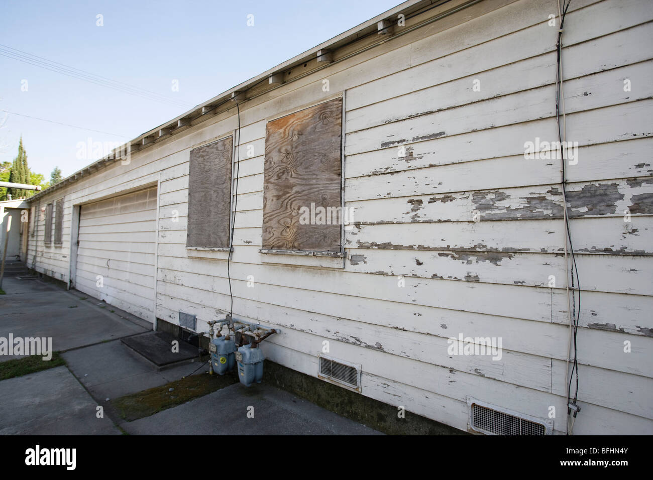 Verlassene Gebäude mit Bohlen ausgelegter Fenstern und abblätternde Farbe Stockfoto