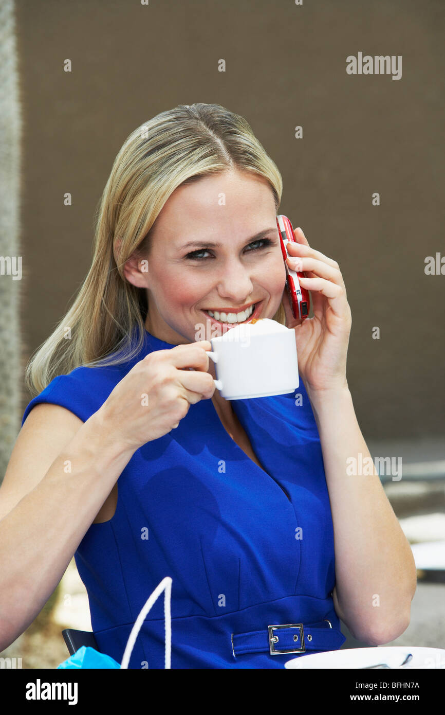 Frau im Gespräch auf ein Handy in einem Coffee-Shop Stockfoto
