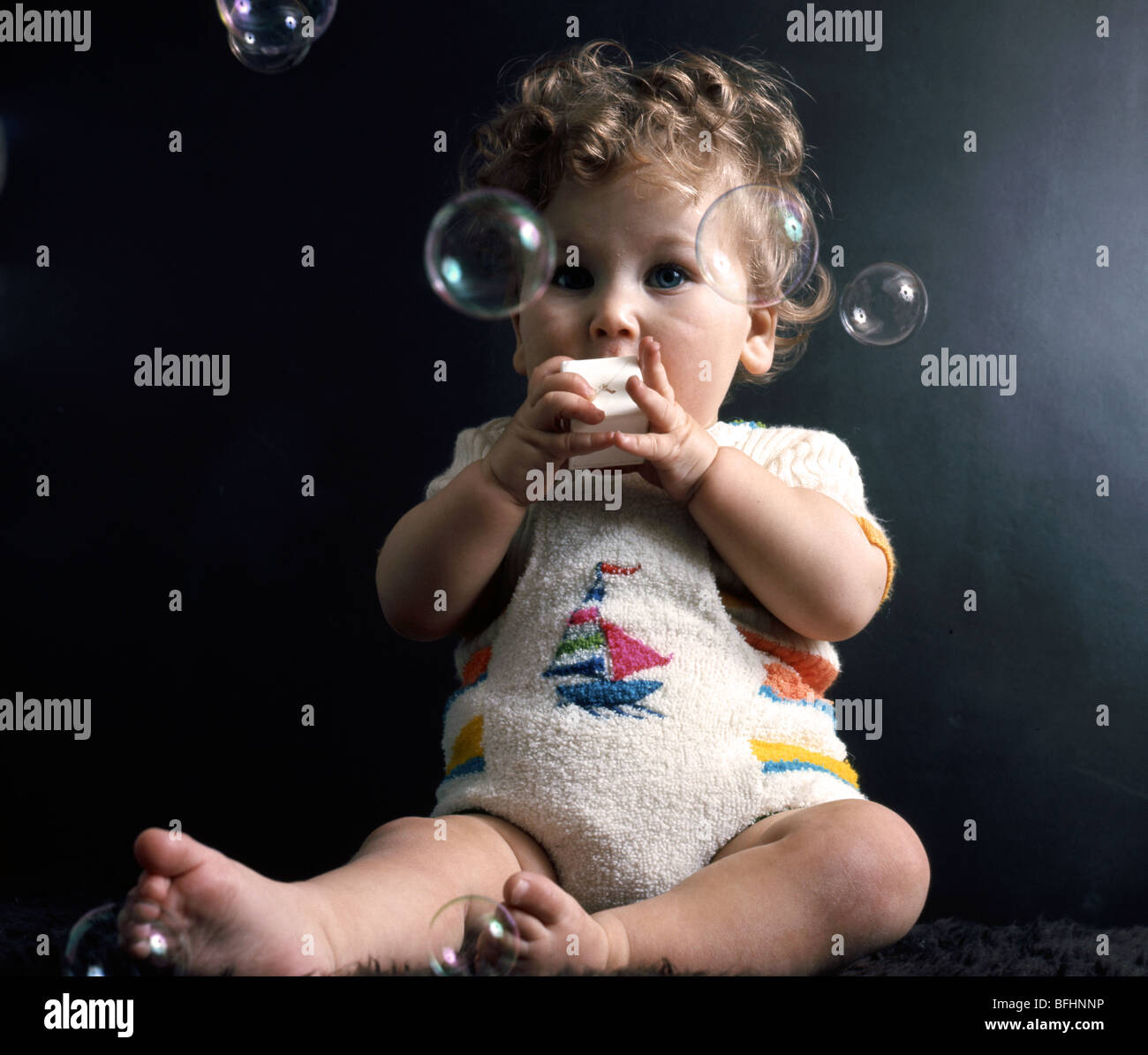 Sechs Monate altes Baby fasziniert mit Seifenblasen Stockfoto