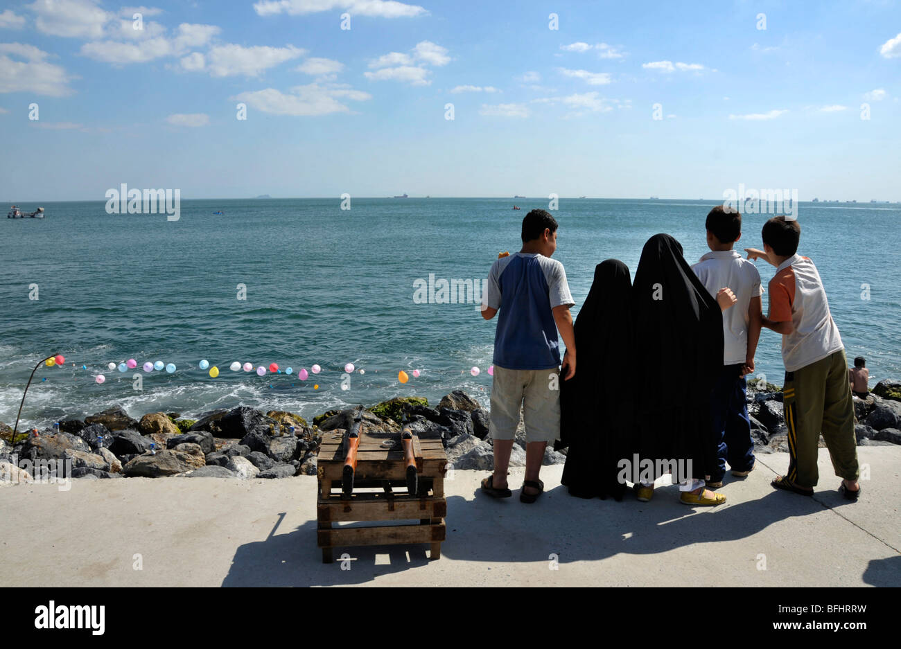 Rücken der fünf Kinder, zwei kleine Mädchen in Schwarz hijabs und drei Jungen in Hosen und T-Shirts im Marmara Meer, Istanbul, Türkei Stockfoto