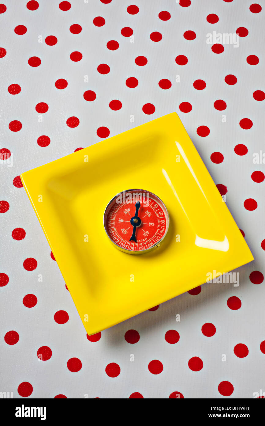 Roter Kompass auf gelbes Schild Stockfoto