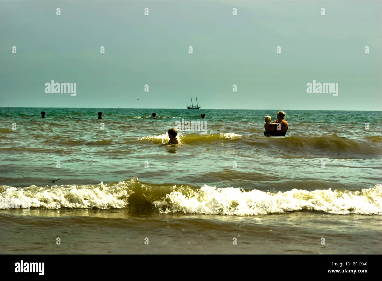 Eine Mutter und zwei Kinder Baden im Meer am Walton auf ganz blöd, Essex England UK Stockfoto