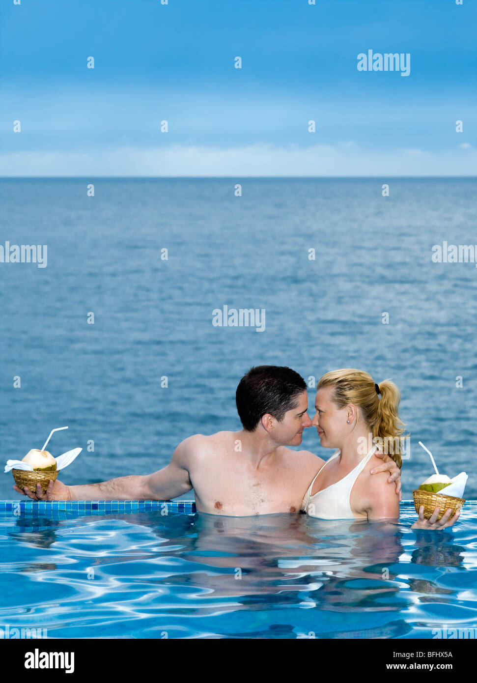 schöne Kaukasischen Paare genießen ihren Urlaub in einem schönen Swimmingpool am Meer Stockfoto