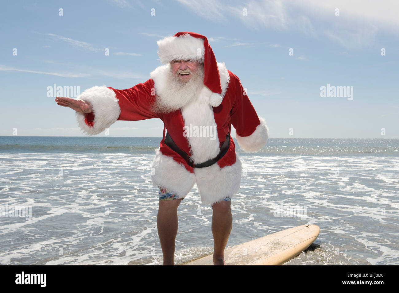 Father Christmas Surfbretter am Rand Wassers Stockfoto