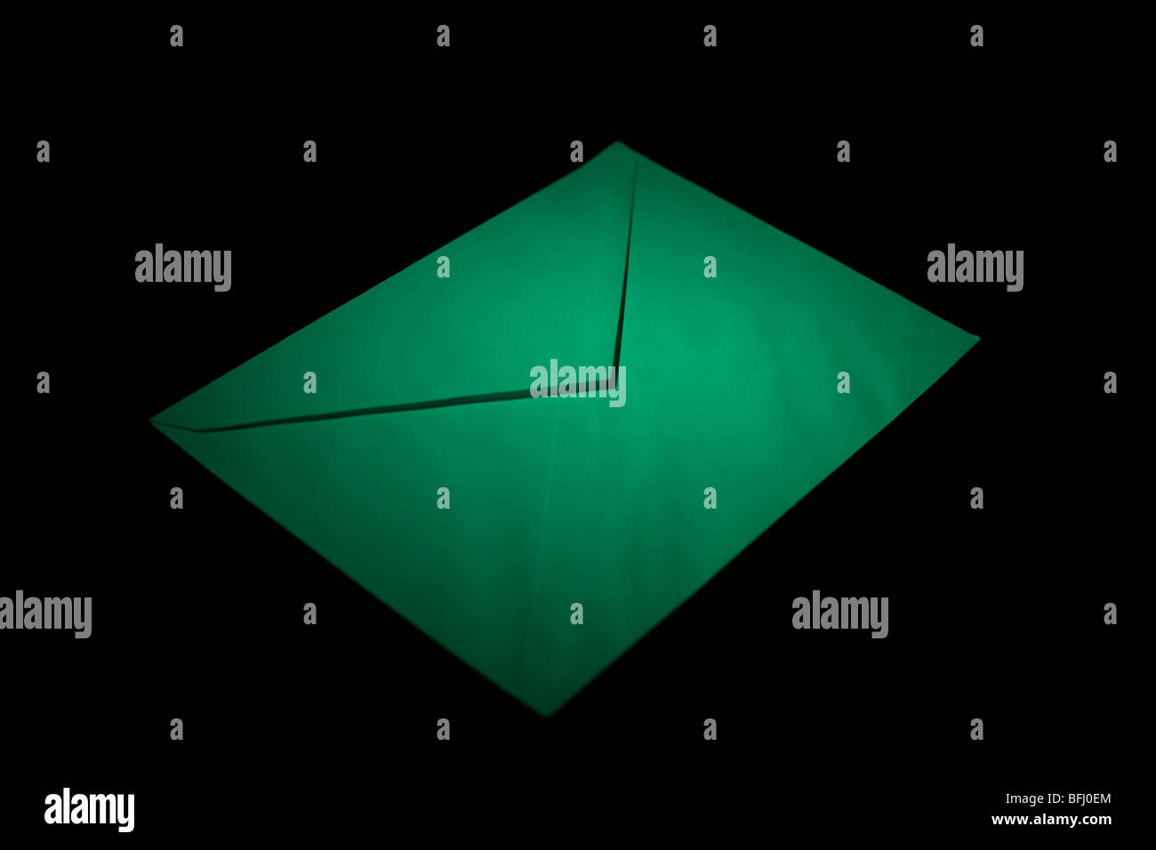 Umschlag mit grünen spot-Licht auf schwarzem Hintergrund geschlossen Stockfoto