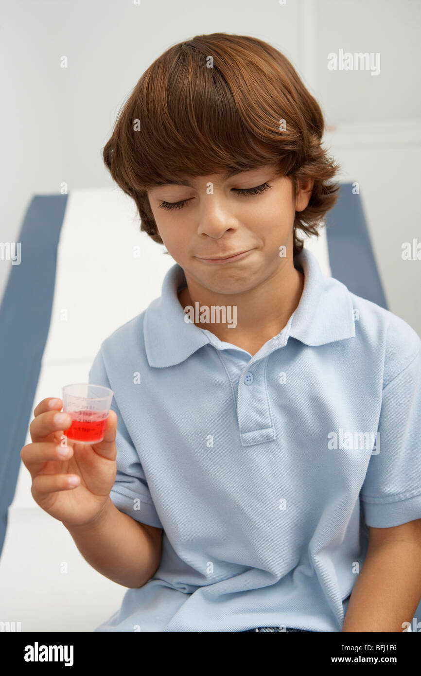 Boy Holding flüssige Medizin Stockfoto