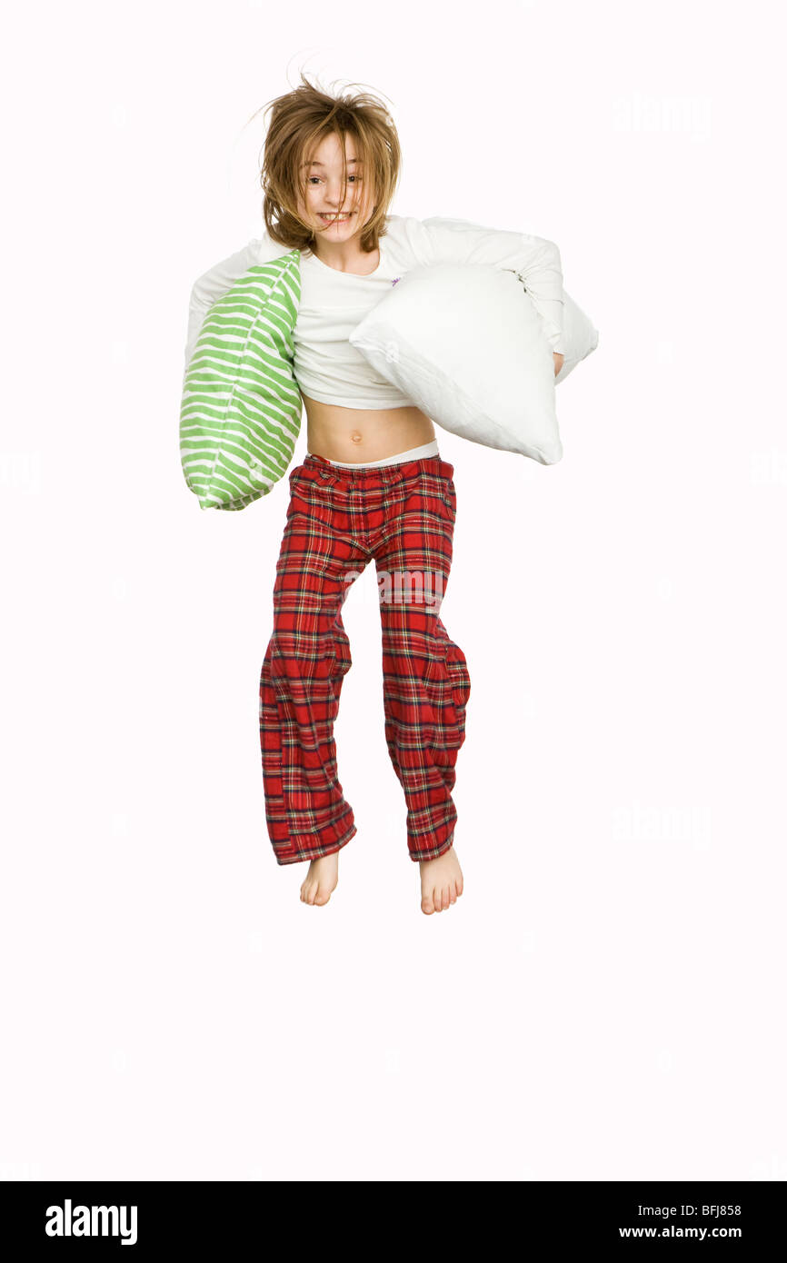 Ein Mädchen trägt einen Schlafanzug und spielen mit Kissen. Stockfoto