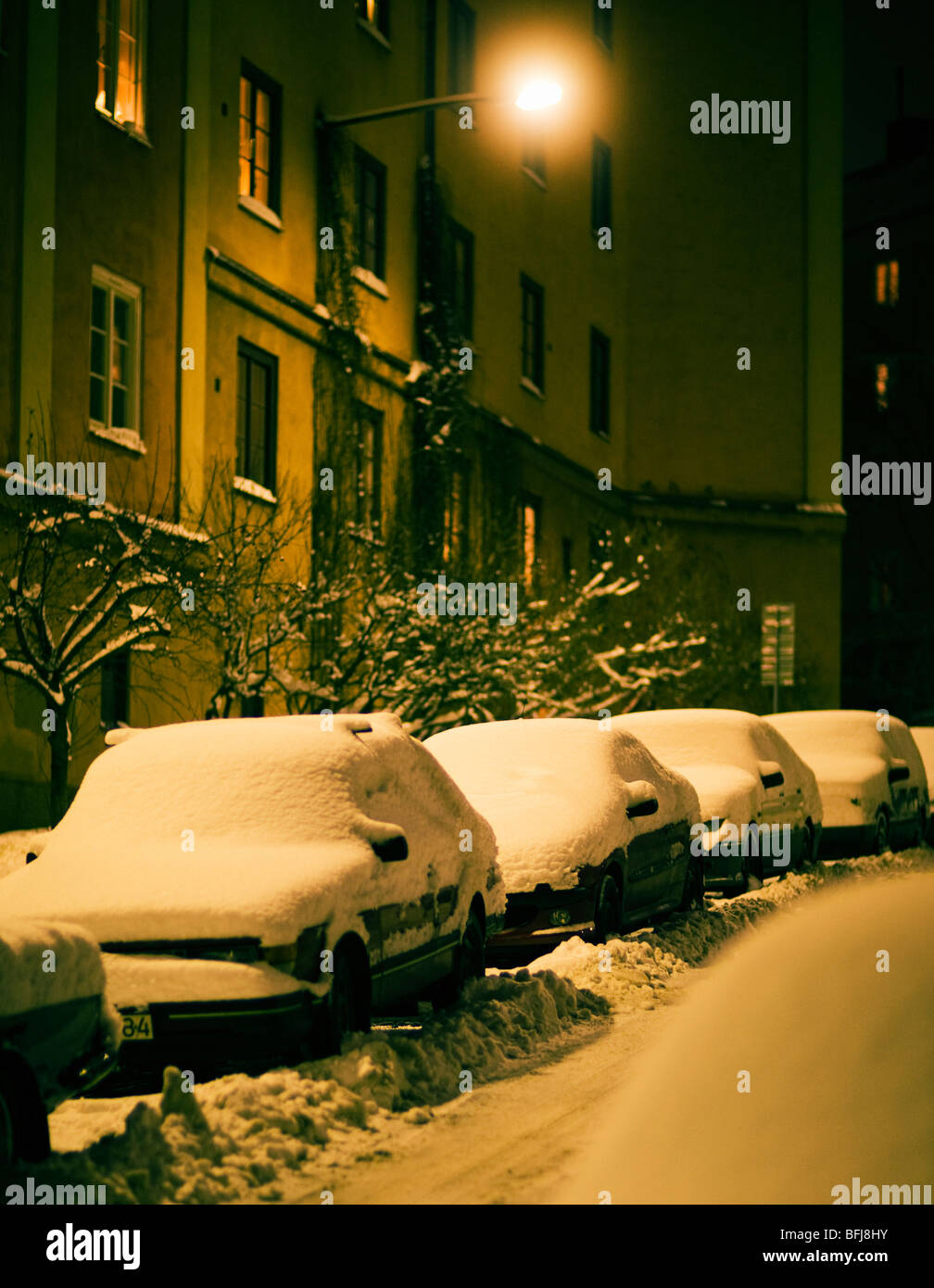 Verschneite Autos auf einer Straße, Schweden. Stockfoto