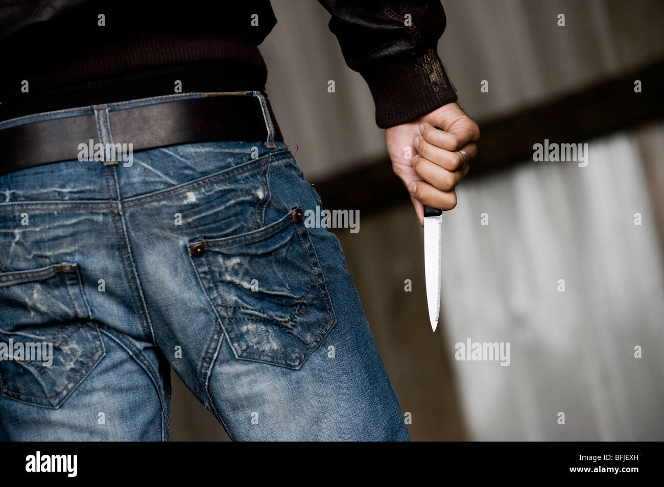 Rückansicht eines Mannes mit einem Messer. Stockfoto