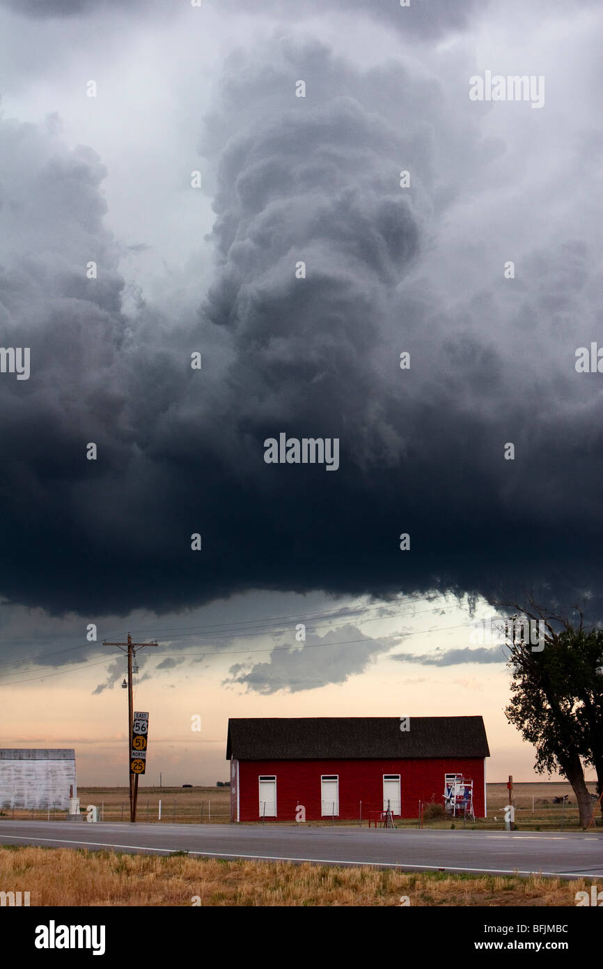 Eine dunkle, bedrohliche Wolke schwebt über einem roten Gebäude im ländlichen Kansas, USA, 10. Juni 2009. Stockfoto