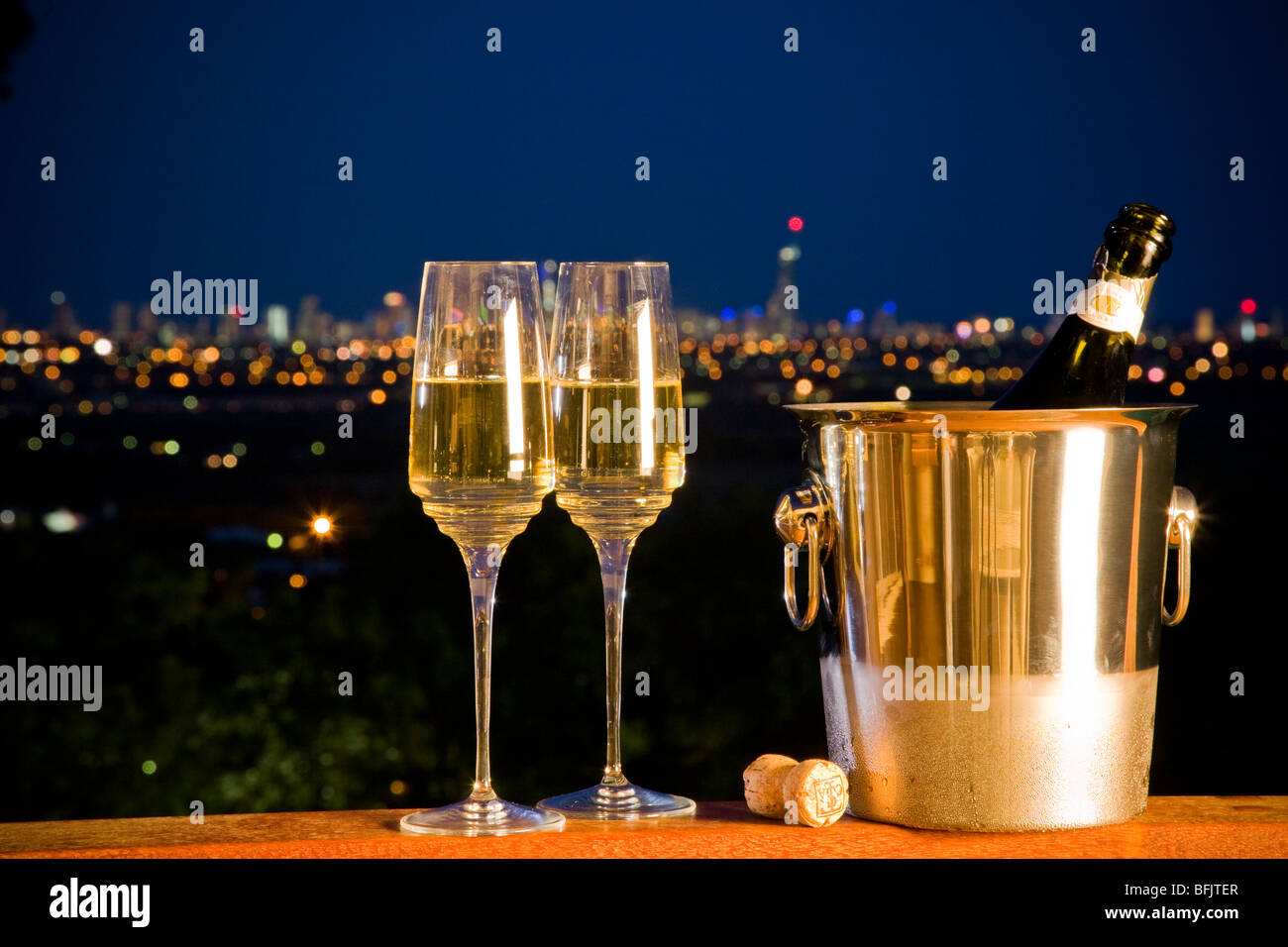 Flasche Champagner und zwei Gläser mit Nacht Skyline im Hintergrund mit der Stadt iights Stockfoto