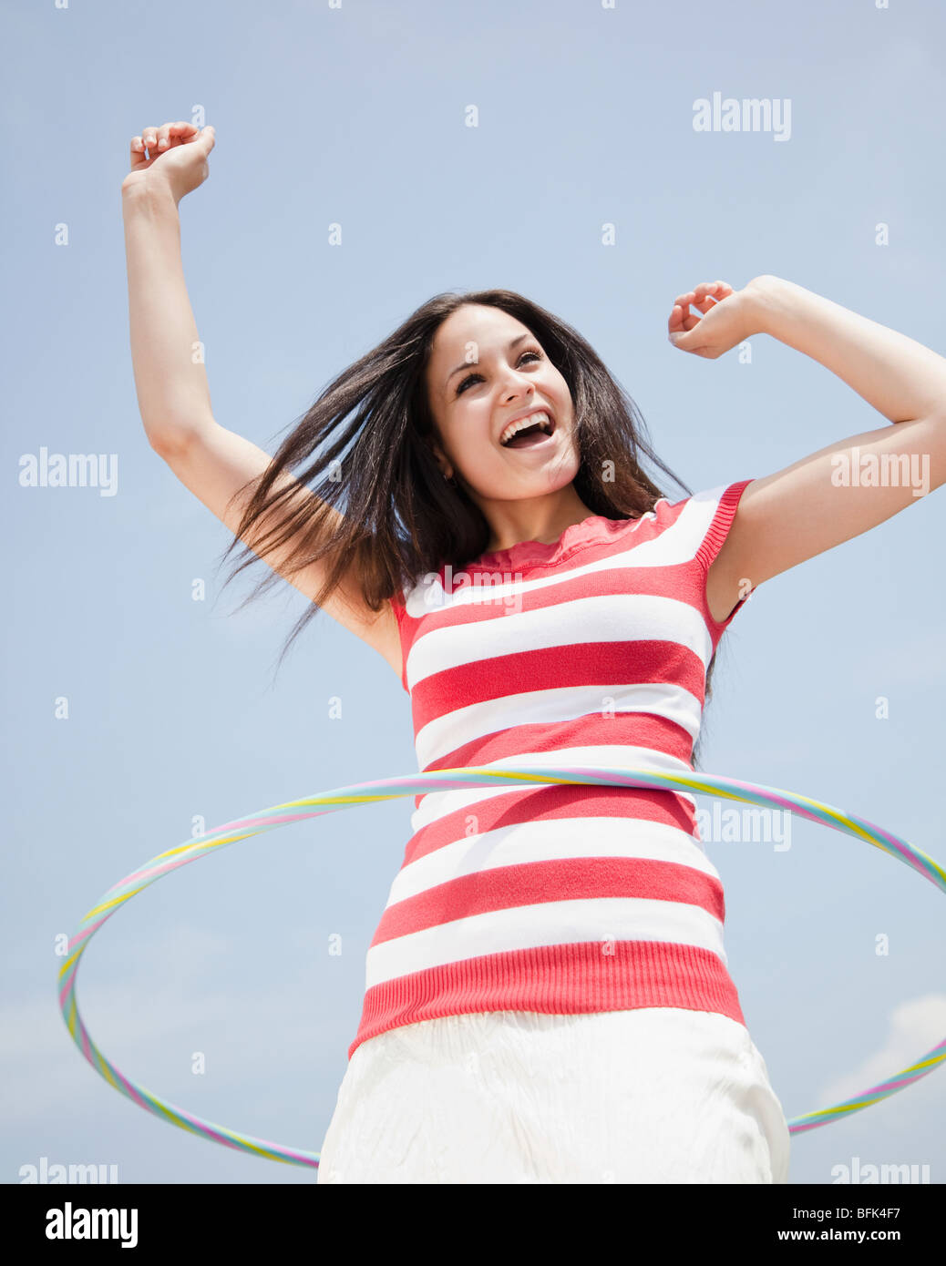 Gemischte Rassen Frau Spinning Hula-Hoop Stockfoto