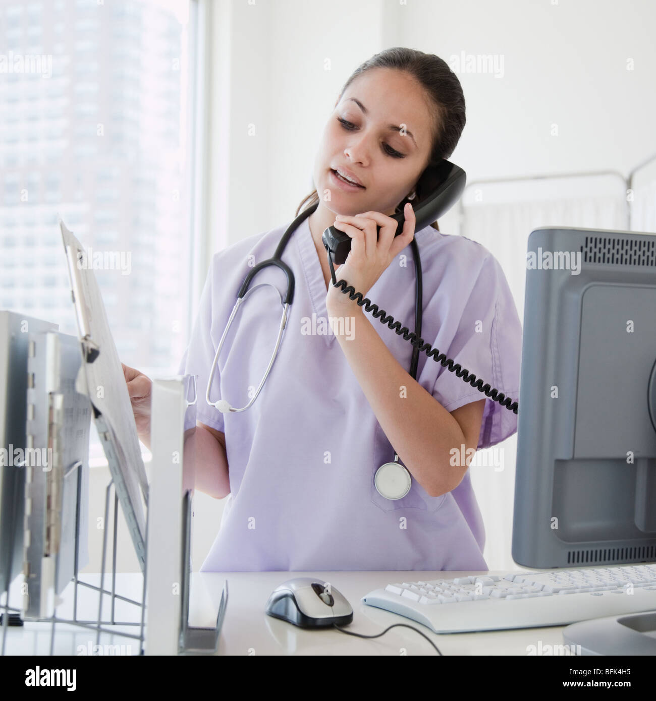 Gemischte Rassen Krankenschwester am Telefon im Krankenhaus sprechen Stockfoto