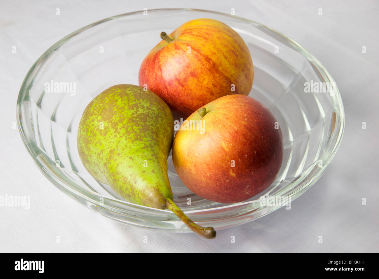 Zwei englische Cox Äpfel und eine Konferenz Birne in eine Glasschüssel Stockfoto