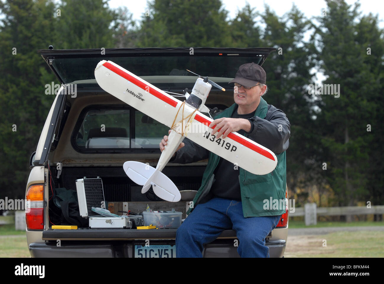 Ein Mann arbeitet in seinem Modellflugzeug, wie er es war am Hammonasset Beach State Park in Madison, Connecticut USA fliegen Stockfoto