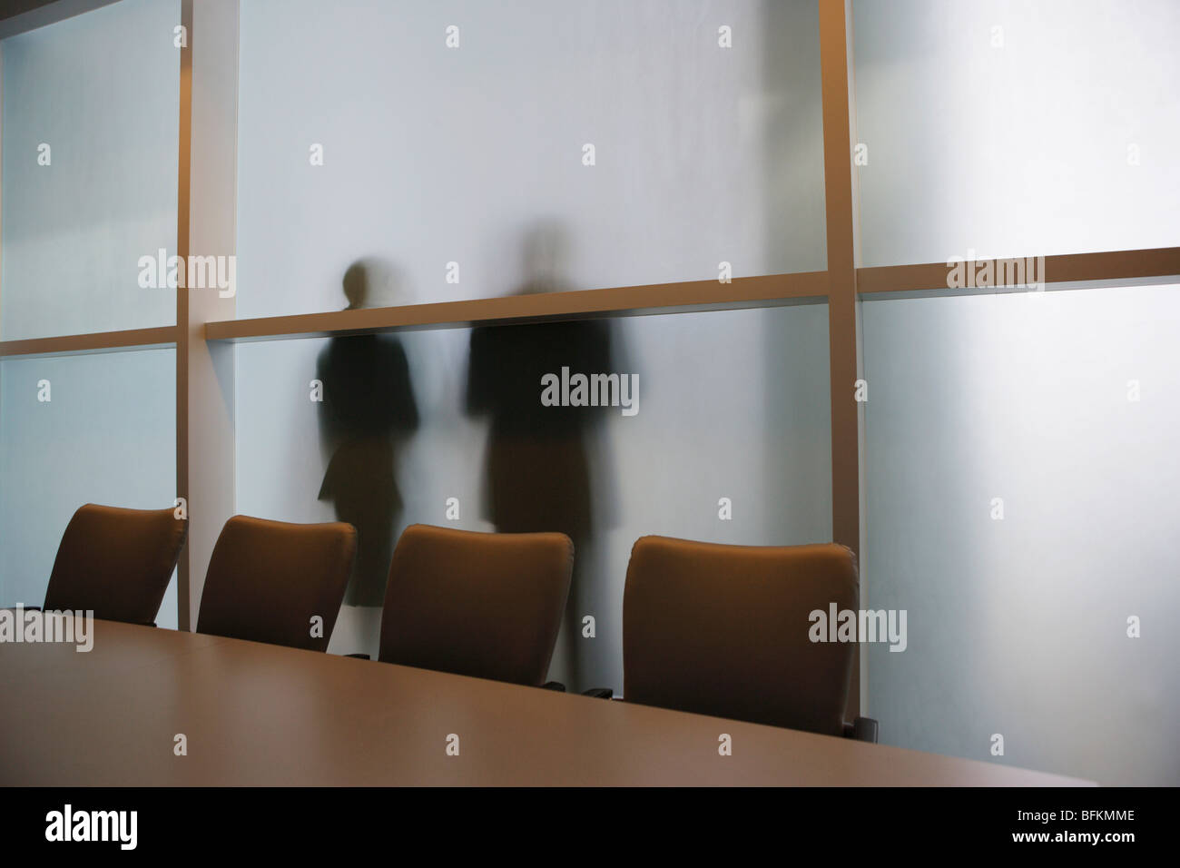 Silhouette der Geschäftsleute durch Milchglas Wand Stockfoto