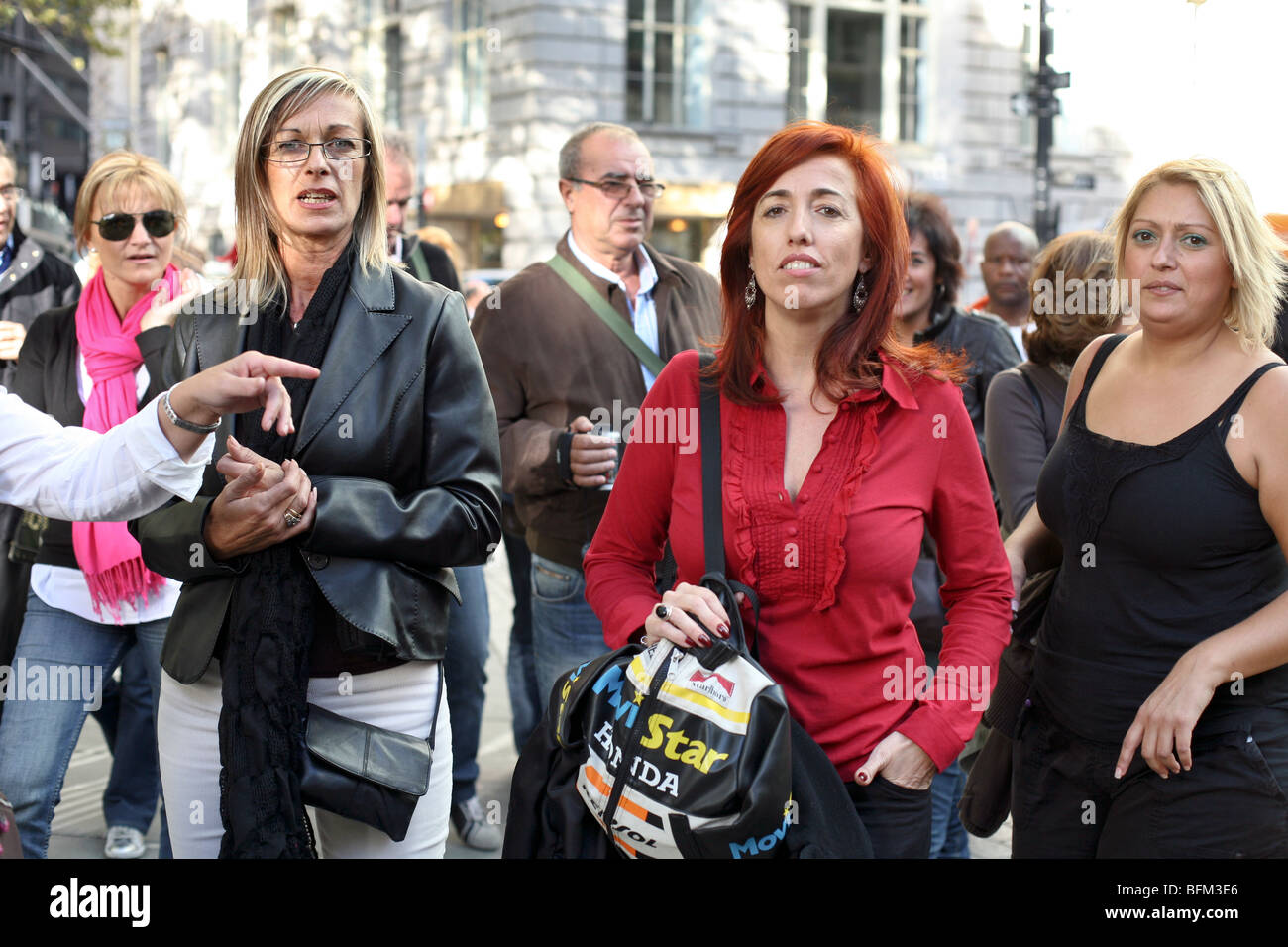 drei resolute Frauen an der Spitze einer Menge von fremden eilen über Broadway Zebrastreifen im unteren Manhattan New York City Stockfoto