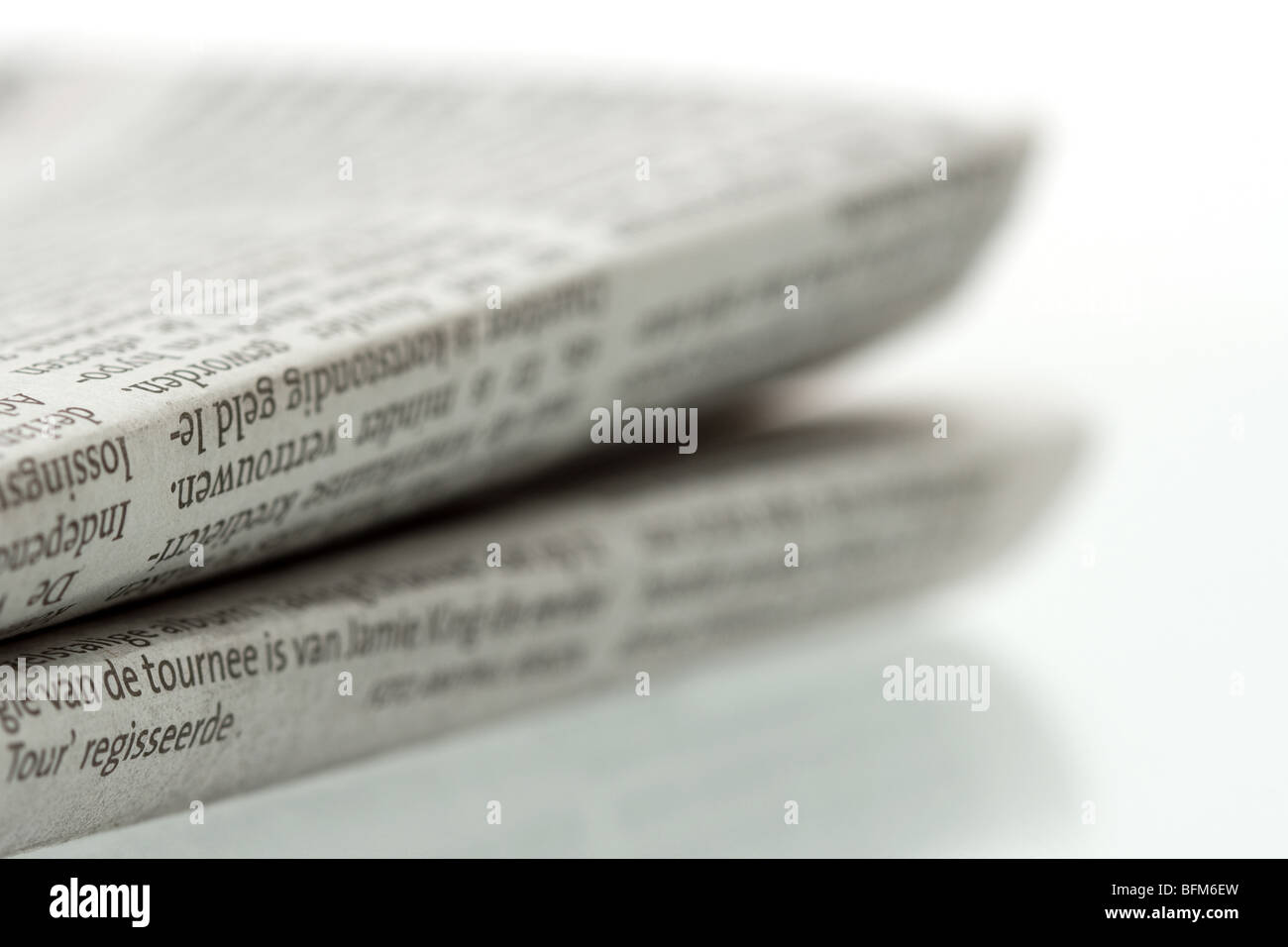 Gefaltete Zeitung auf glänzenden reflektierenden Oberfläche - Nahaufnahme Fokus auf Vordergrund gedreht Stockfoto