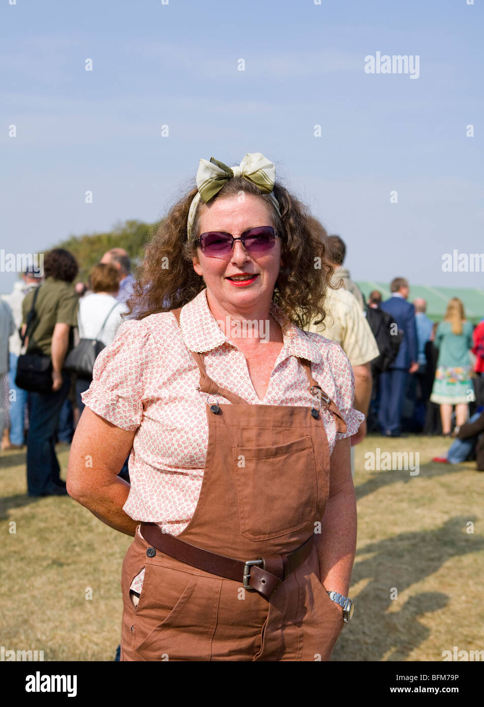 Reife Frau gekleidet als Land Mädchen beim Goodwood Revival, Chichester, West Sussex, England. Stockfoto