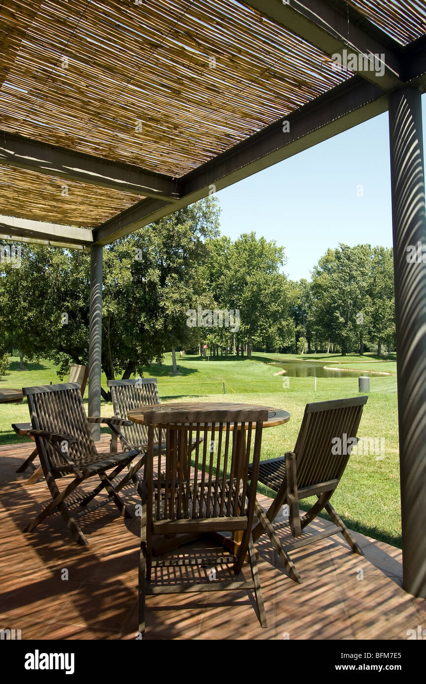Terrasse mit Tisch und Stühlen unter Schutz von Stroh. Mit Blick auf Golfplatz Stockfoto