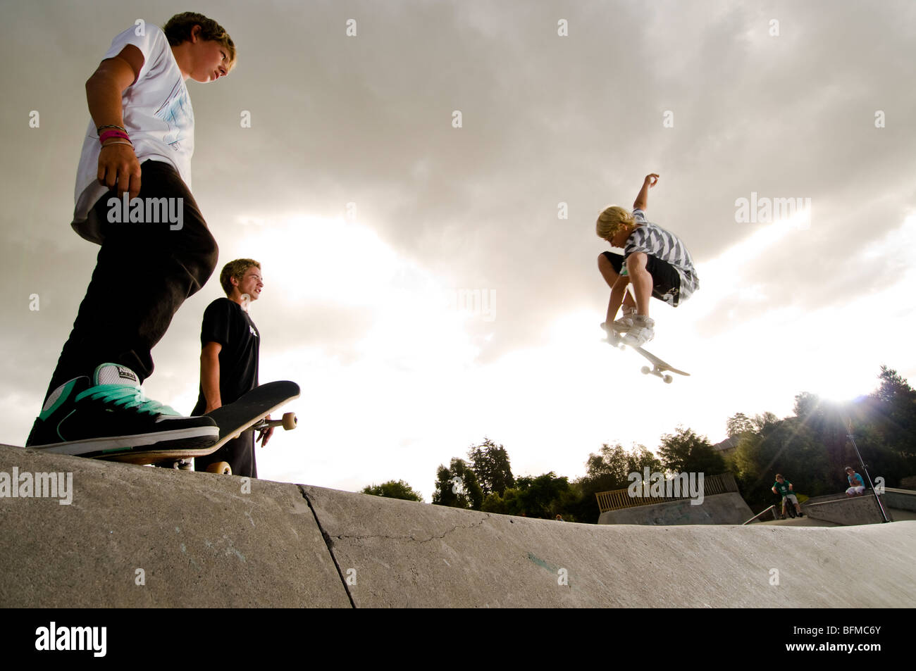 3 jungen machen Tricks im Skatepark mit Sonnenuntergang, Cambridge, Neuseeland, Stockfoto