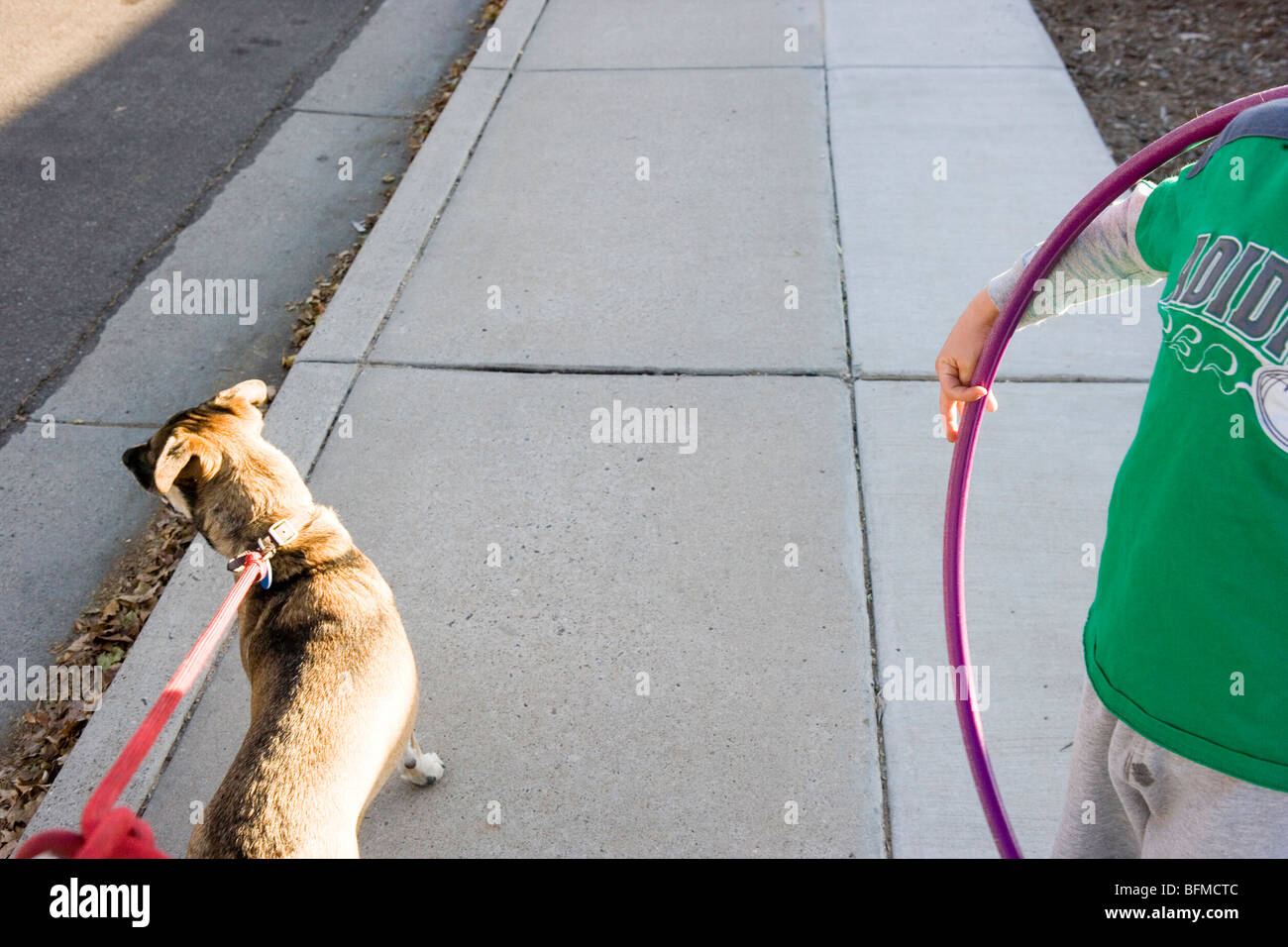 Hund an der Leine und ein Kind mit einem hoolahoop Stockfoto