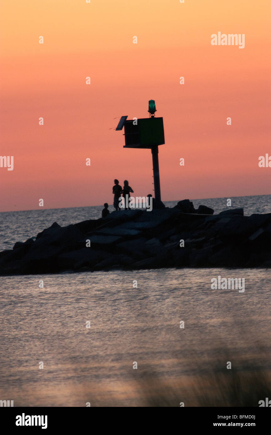 Menschen stehen auf der Mole im Hafen von New Buffalo bei Sonnenuntergang Stockfoto