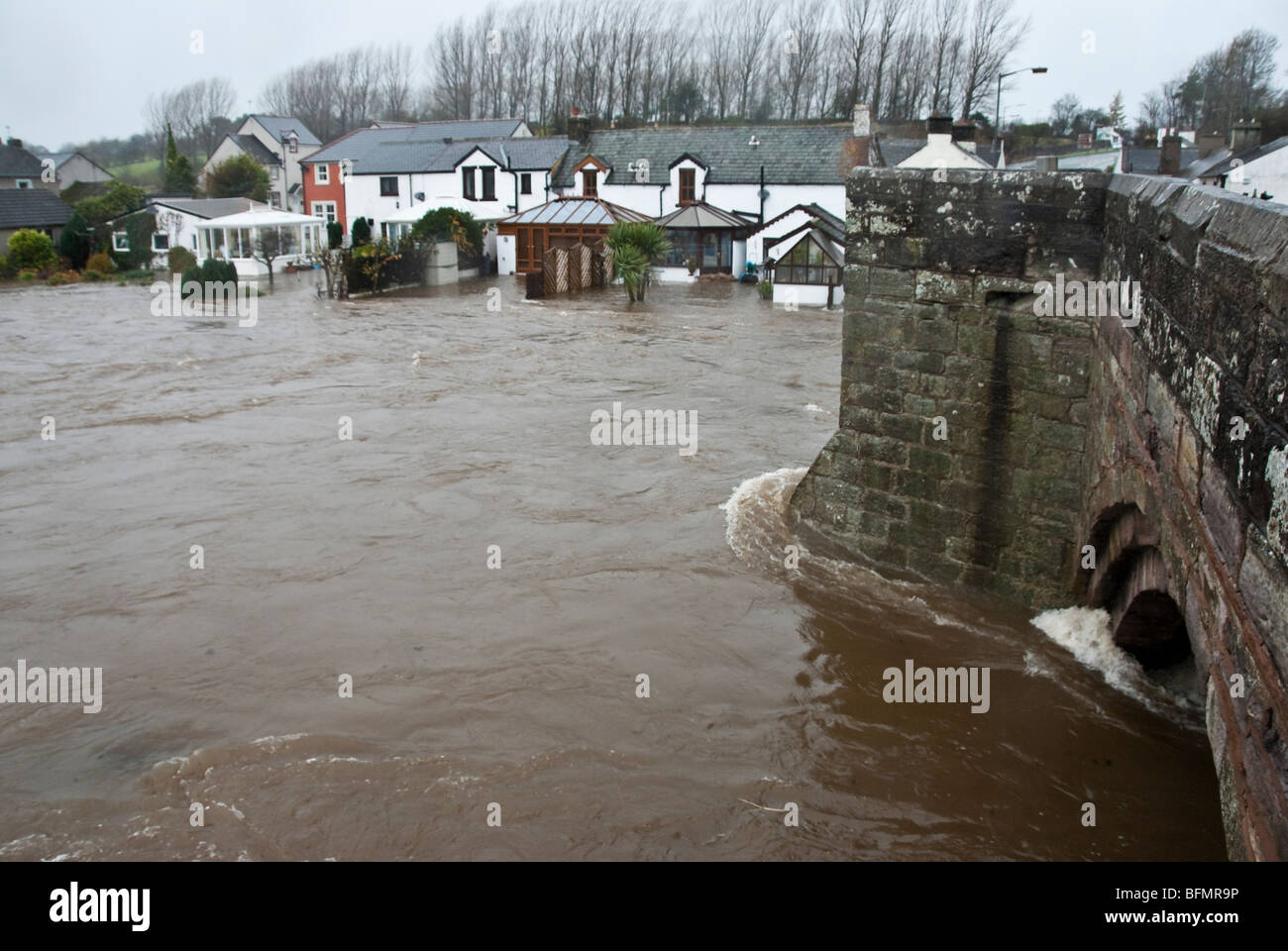 Eamont Brücke in der Nähe von Penrith, Cumbria, England, UK mit Hochwasser aus dem Fluss Eamont fließt aus Ullswater Überschwemmungen Haus Stockfoto