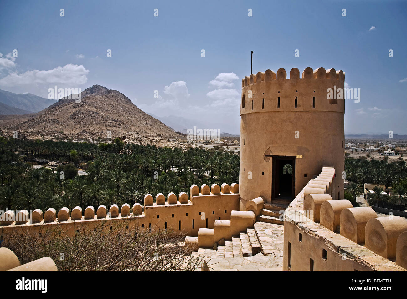 Oman, Nakhl, ein Wachturm in Fort Nakhl mit Blick auf das Hajar-Gebirge im Hintergrund. Stockfoto