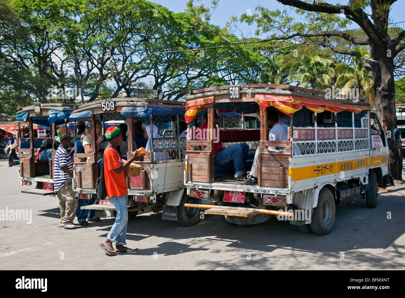 Tansania, Sansibar, Stonetown. Bunte Land Busse, bekannt als Daladala, Reihen sich außerhalb der städtischen Markthalle. Stockfoto