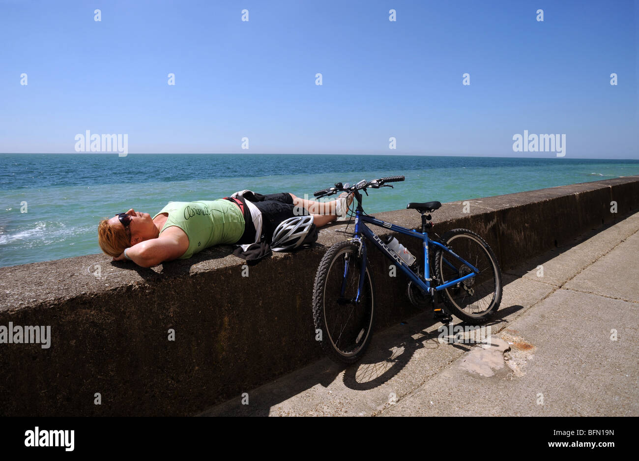 Ein Radfahrer hält, genießen Sie die Sonne auf dem Undercliff Weg zwischen Brighton und peacehaven Stockfoto